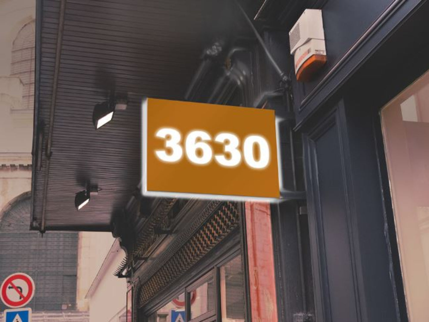 Street sign with the number 3630 on a building facade.