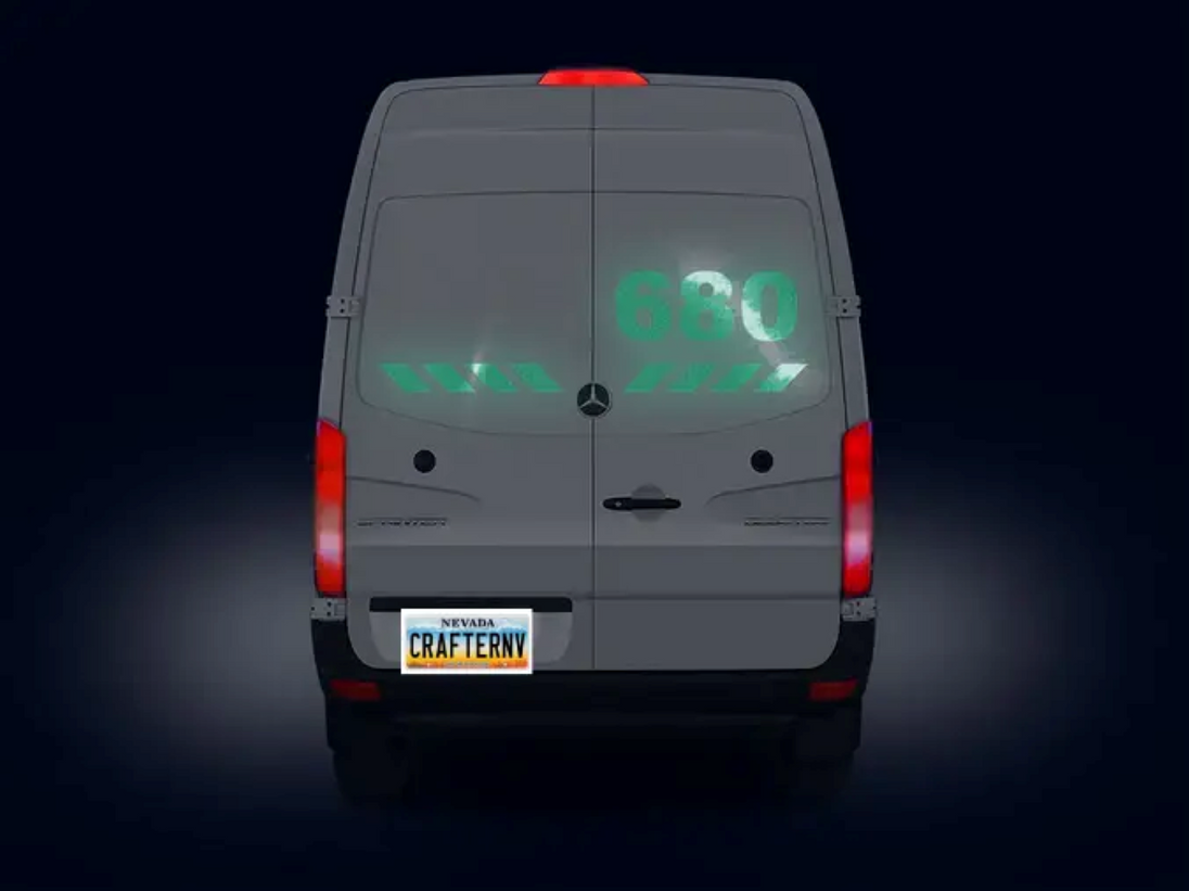 Back view of a gray van with digital display on a black background