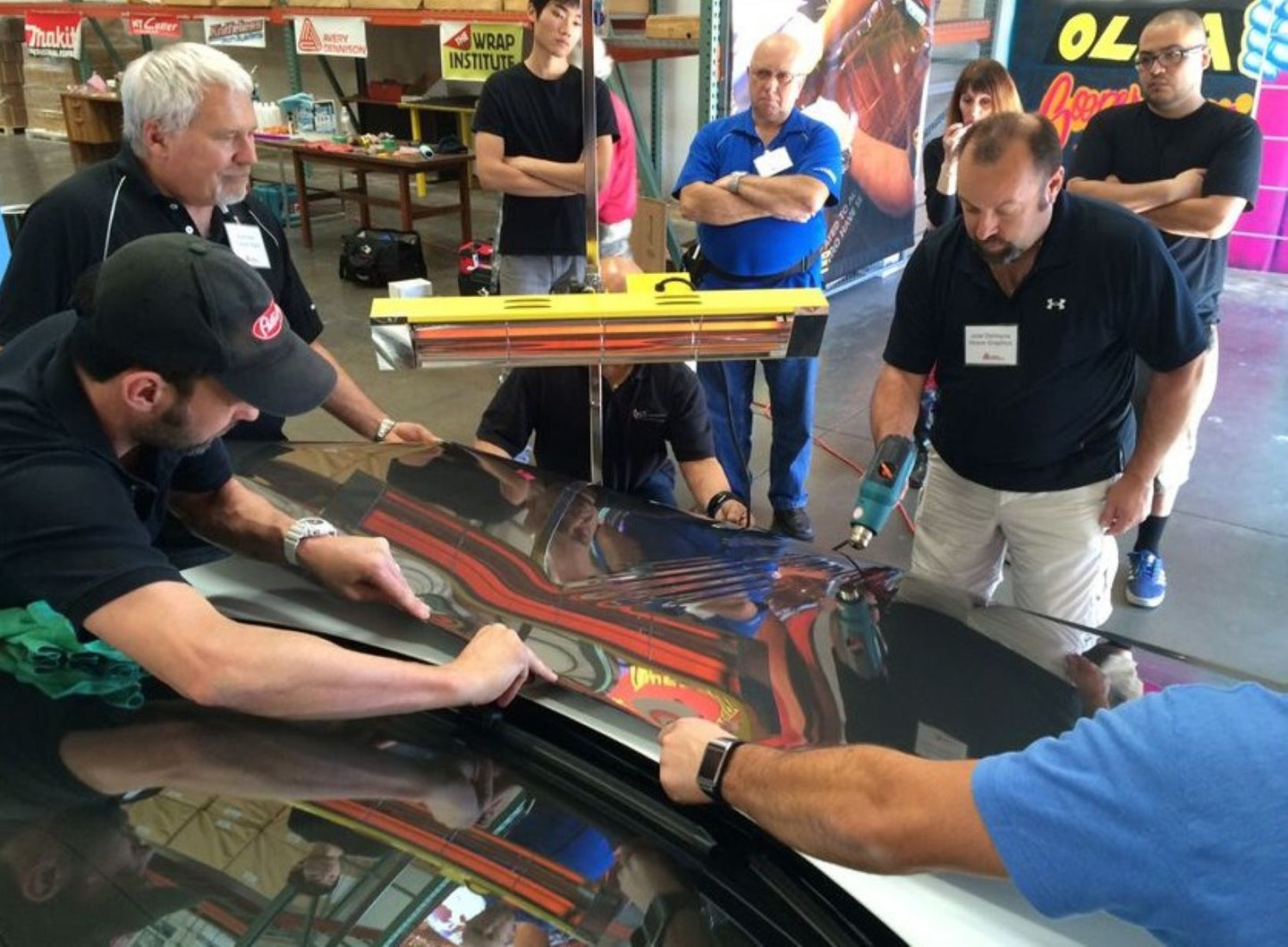 Group of people working on a car in a garage setting