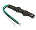 A black plastic electrical terminal block with three attached wires (green, black, and white) on a plain white background.