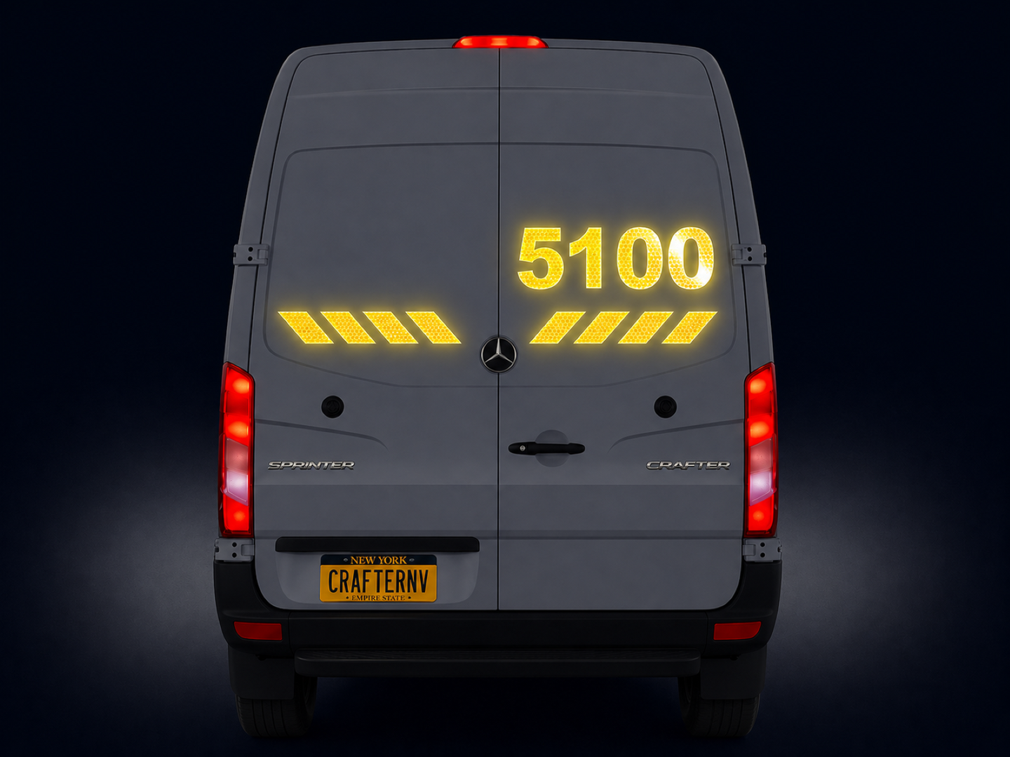 Back view of a gray van with yellow numbering and brake lights on a black background