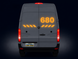 Back view of a van with large '680' displayed on the door against a dark background
