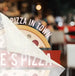 Blurred image of a pizza with 'Pizza in Town' text overlay
