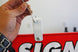 Hand attaching a metal clip to a red sign with 'SIGN' printed on it.