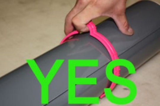 Hand holding a pink object with the word 'YES' in green text overlay on a neutral background