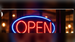 Illustrative red and blue illuminated OPEN neon storefront window sign; application illustration for Allanson SS1235ICH indoor neon power supply
