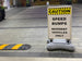 Caution sign for speed bumps with resident vehicles only on a paved area.