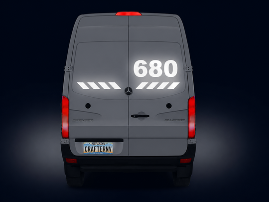 Gray van with reflective numbers and symbols on a dark background