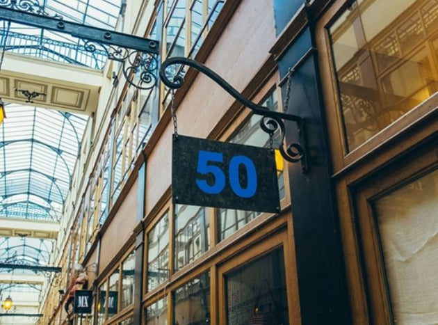 Building facade with a sign displaying the number 50 in an indoor setting with glass ceiling