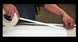 Person applying tape to a long strip of paper or fabric.