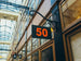 Sign with the number 50 hanging from a building in an indoor shopping arcade.