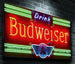 Neon Budweiser sign on a brick wall