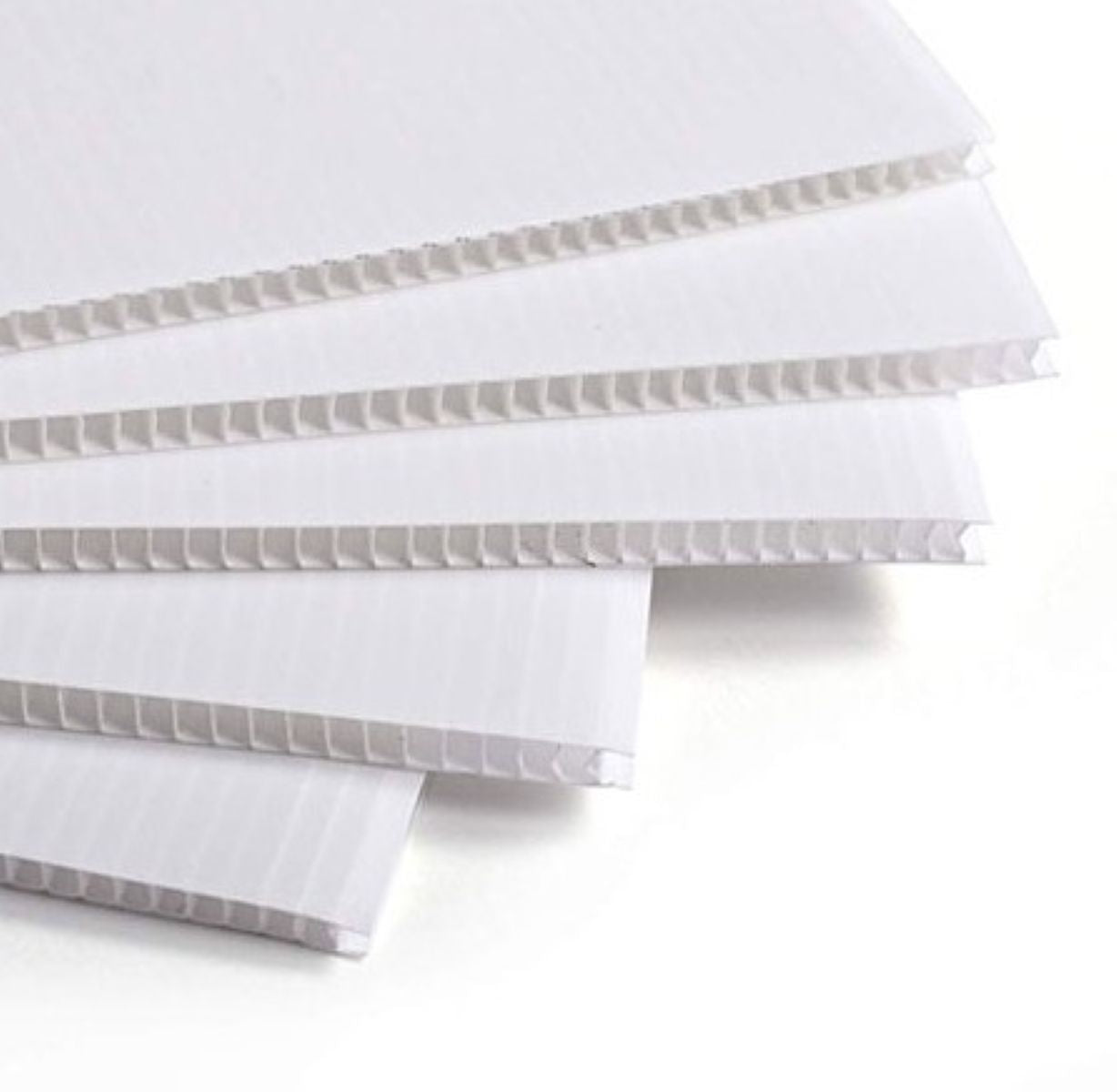 Stack of white corrugated plastic sheets on a white background