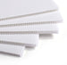 Stack of white corrugated plastic sheets on a white background