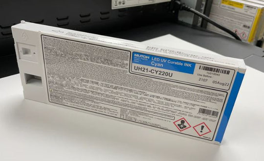 Cyan ink cartridge with label on a white surface