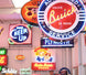 Collection of vintage neon signs including Buick, Cheer Up, and Schlitz.