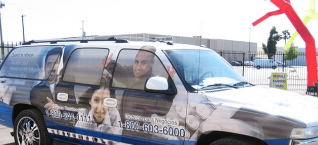 Van with a large advertisement on its side featuring multiple people.