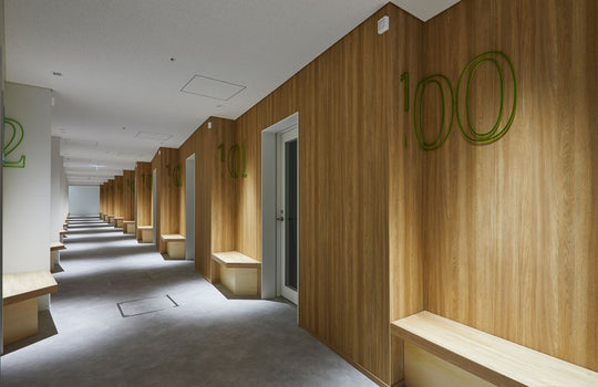 Long hallway with wooden walls and benches in a modern building.