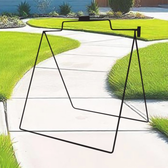 Black metal stand on a garden path with green grass and plants in the background