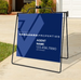 Real estate sign for Vanguard Properties with contact information on a stand outdoors.