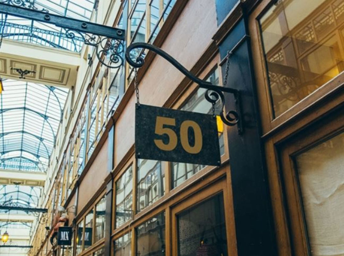 Building facade with a sign displaying the number 50 in an indoor setting with glass ceiling