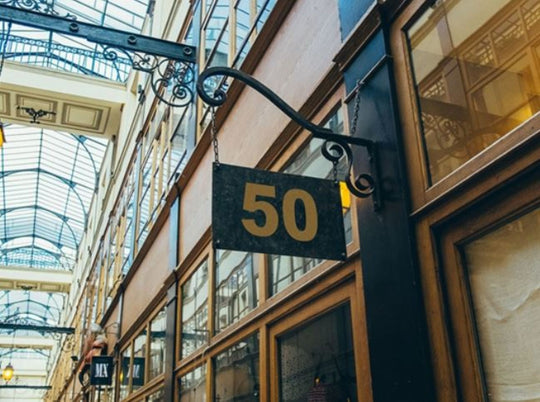 Building facade with a sign displaying the number 50 in an indoor setting with glass ceiling