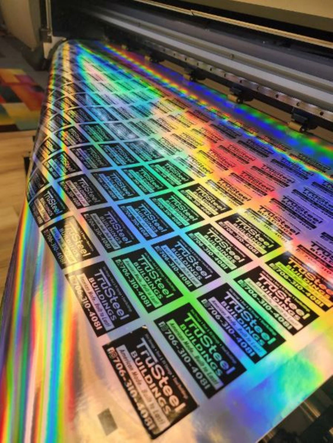 Sheet of holographic labels with a rainbow effect, being printed.