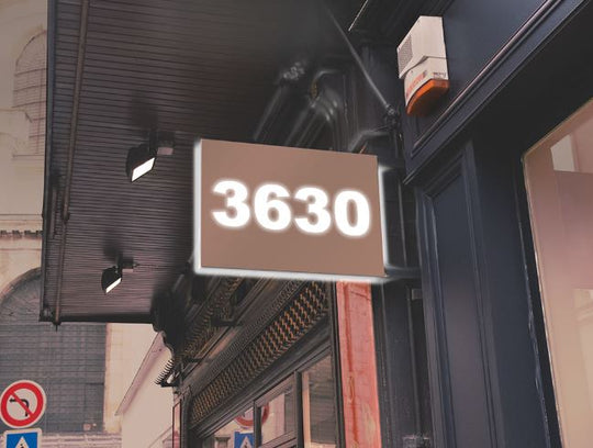 Building facade with a sign displaying the number '3630' on a street corner.