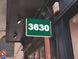 Light Kelly Green sign with the number '3630' on a building facade.