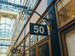 Building facade with a sign displaying the number 50 in an indoor setting with glass ceiling