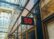 Sign with the number 50 hanging from an architectural structure in a shopping arcade.