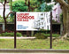 Real estate sign for luxury condos for sale in a residential area.