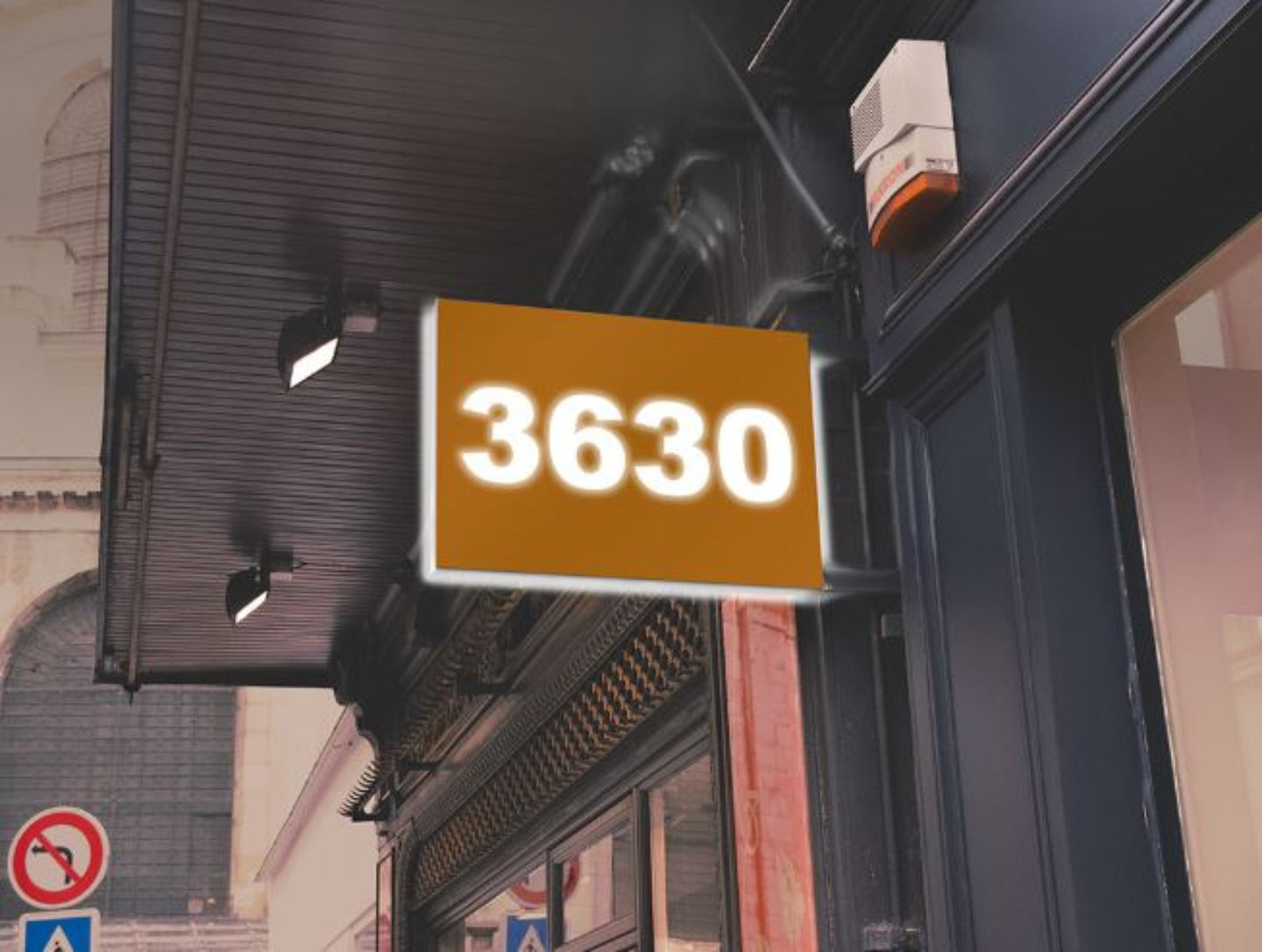 Street sign with the number '3630' on a building facade.