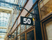 Building facade with a sign displaying the number 50 in an indoor setting with glass ceiling