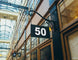 Building facade with a sign displaying the number 50 in an indoor setting with glass ceiling