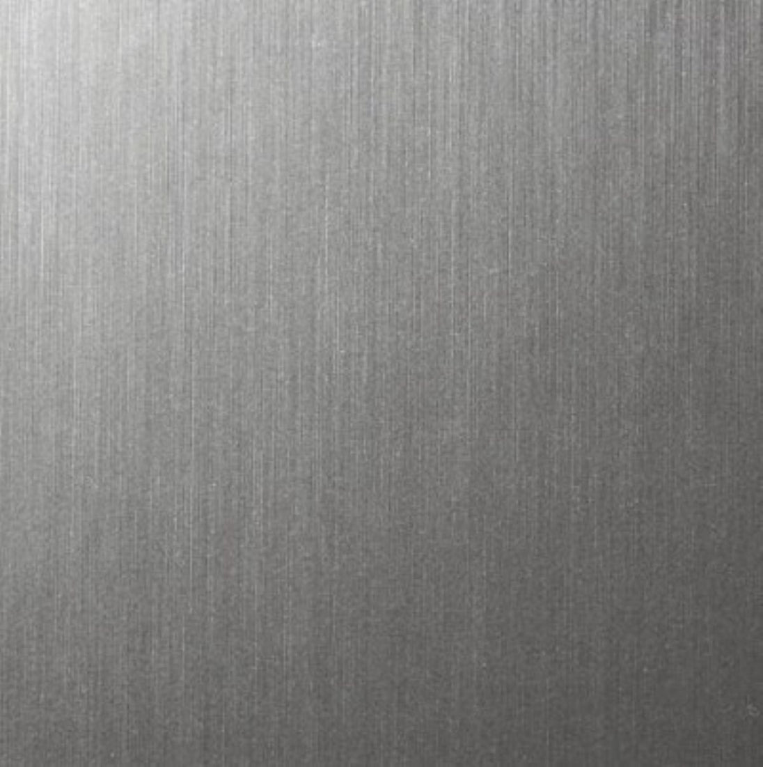 A close-up of a brushed metallic surface with fine vertical texture and a silver-gray finish.