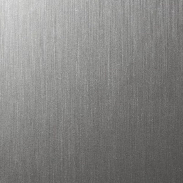 A close-up of a brushed metallic surface with fine vertical texture and a silver-gray finish.