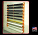 Wall-mounted rack holding various colored pipes with 'Made in the USA' label.