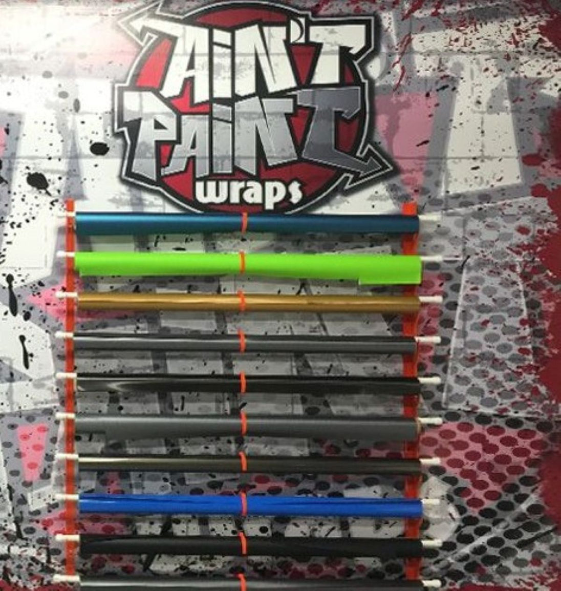 Colorful rolls of vinyl wrap on a textured background with 'Ain't Paint Wraps' branding.
