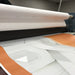 ORAGUARD 290 clear cast overlaminate being applied through a laminator