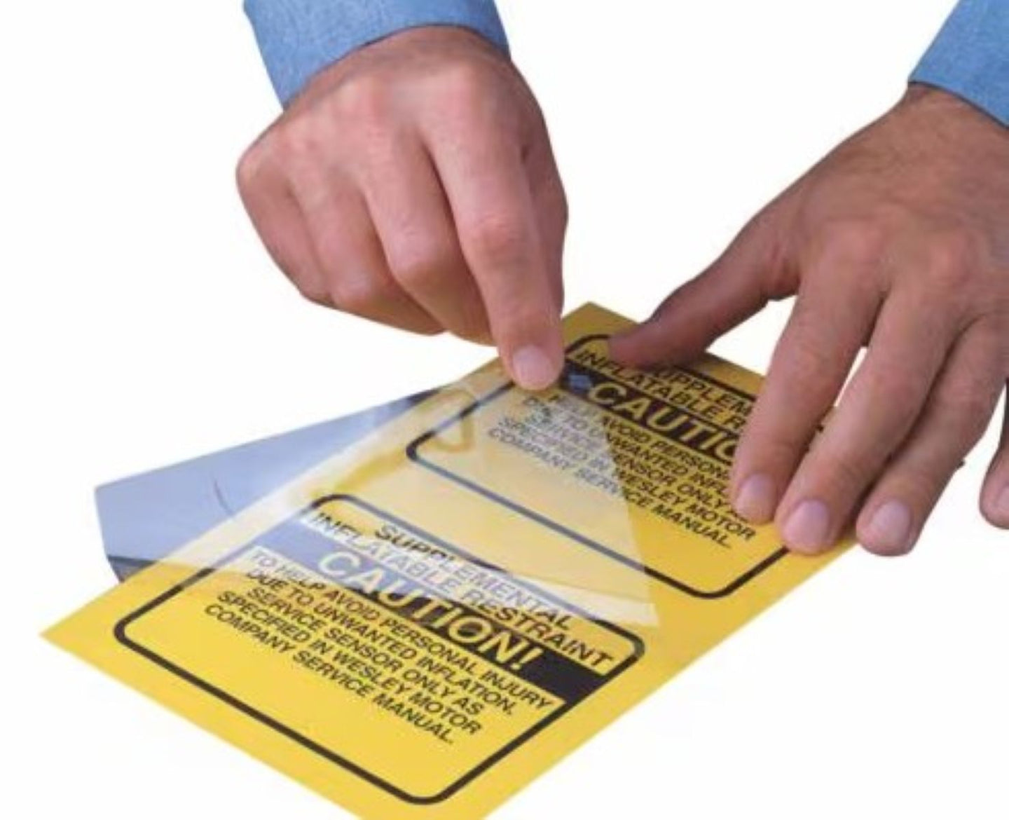 Hands holding a yellow warning label with text on a white background