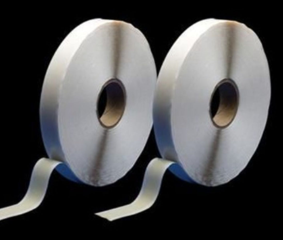 Two rolls of white tape on a black background