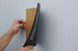 Person using a sanding block on a wall
