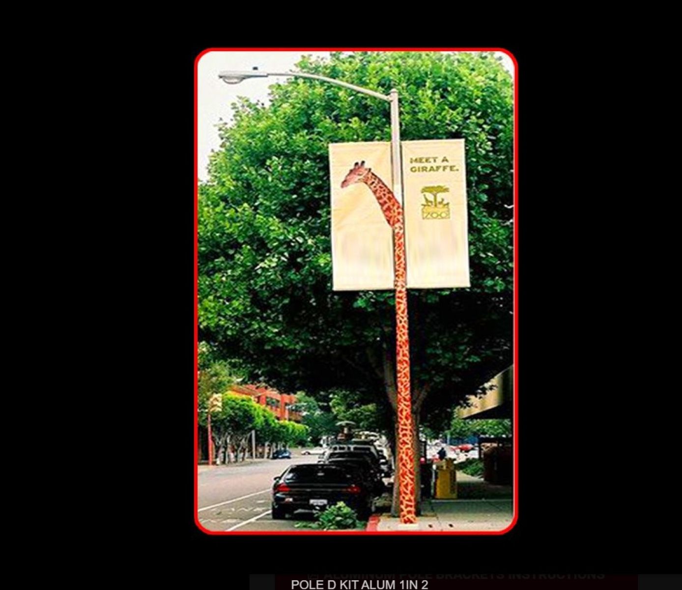 Giraffe-shaped street sign with a banner on a tree-lined street