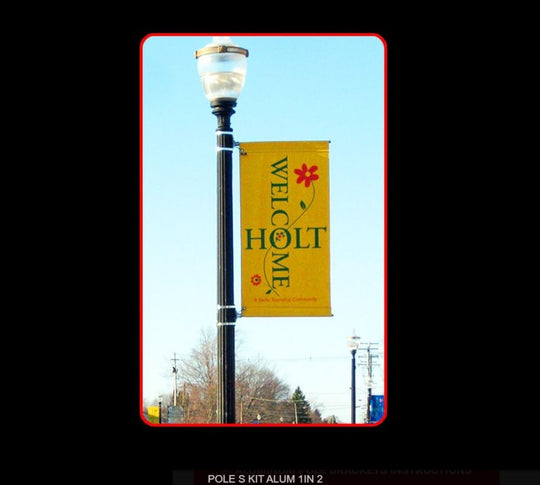 Yellow 'Welcome to Holt' banner on a streetlight against a clear blue sky.