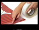 Hand using Power Tape 2 on a red and white striped surface