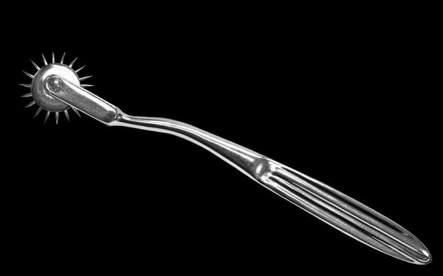 Metallic pricker tool on a black background