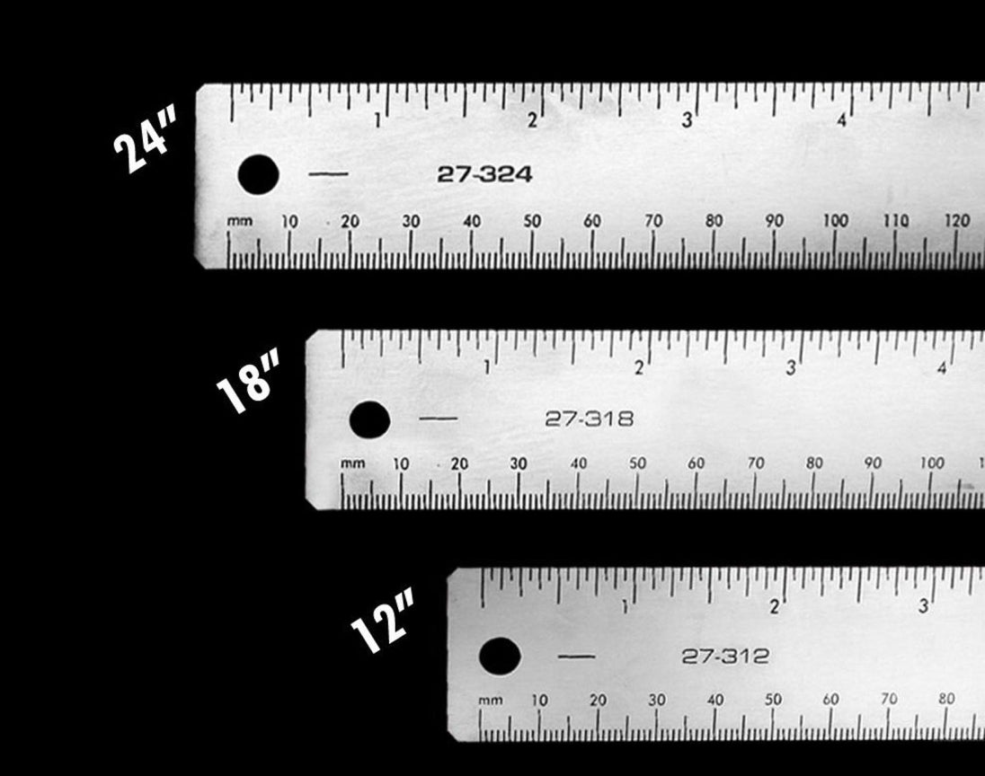 Three metal rulers with measurements in inches and millimeters on a black background