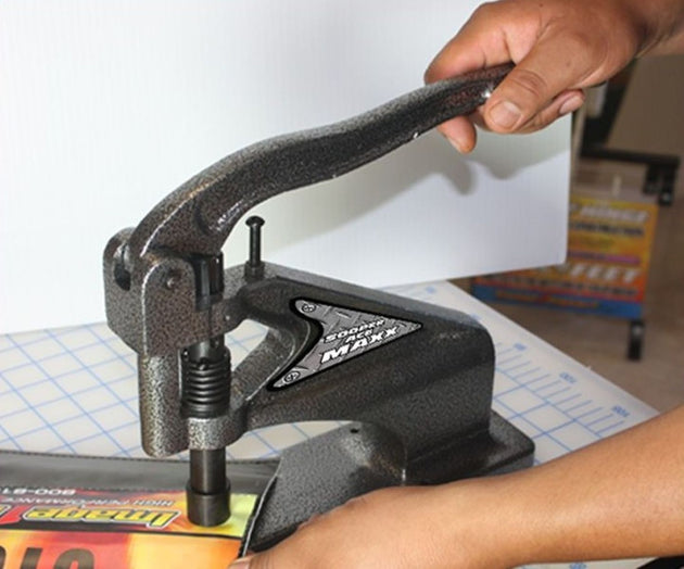 Hand using a paper cutter on a table with a white background