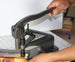 Hand using a paper cutter on a table with a white background